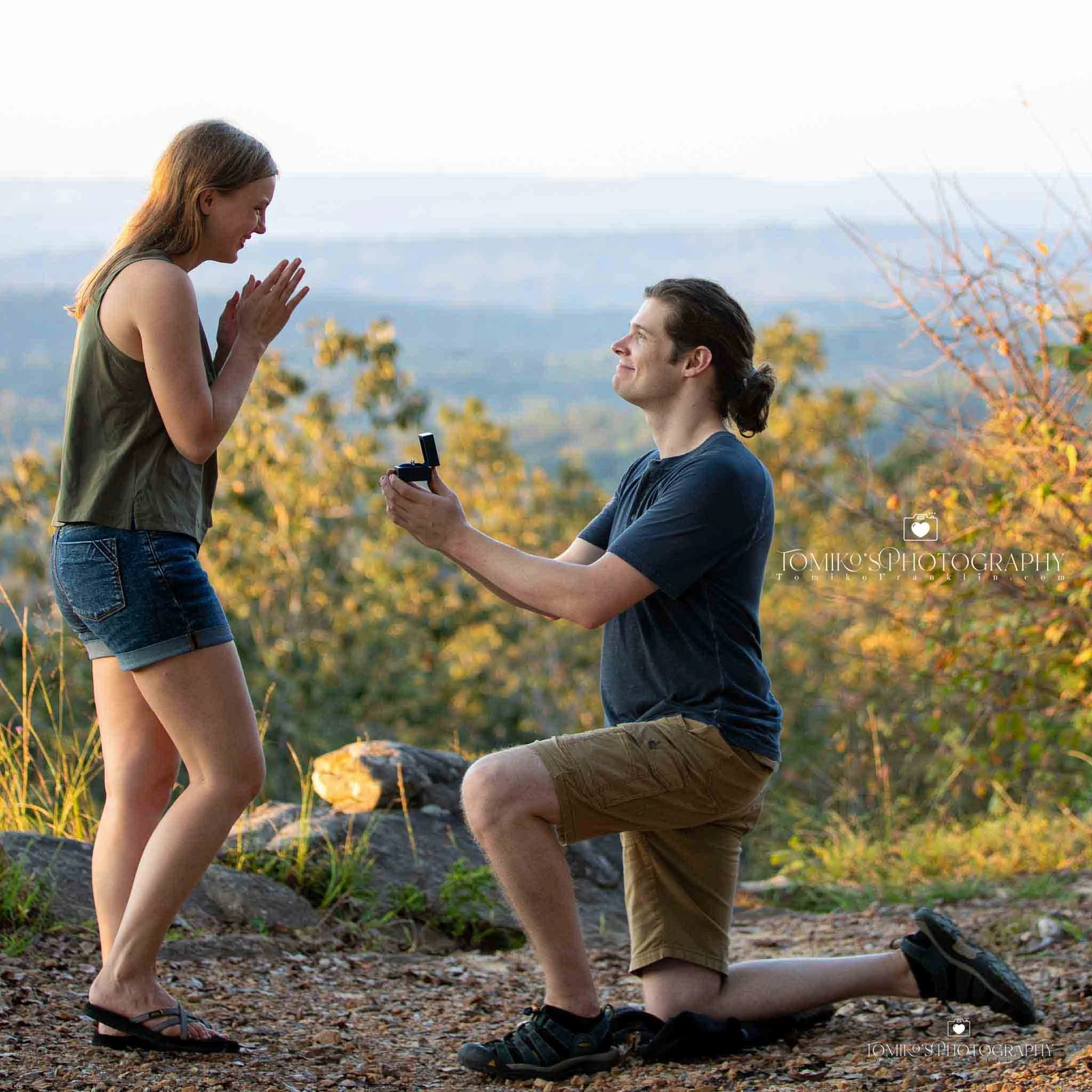 Surprise proposal photo of a Birmingham couple as he asks his girlfriend to marry him. Emotional, candid reaction photography captured by a Birmingham AL proposal photographer specializing in secret proposal planning, romantic lighting, and iconic Bi