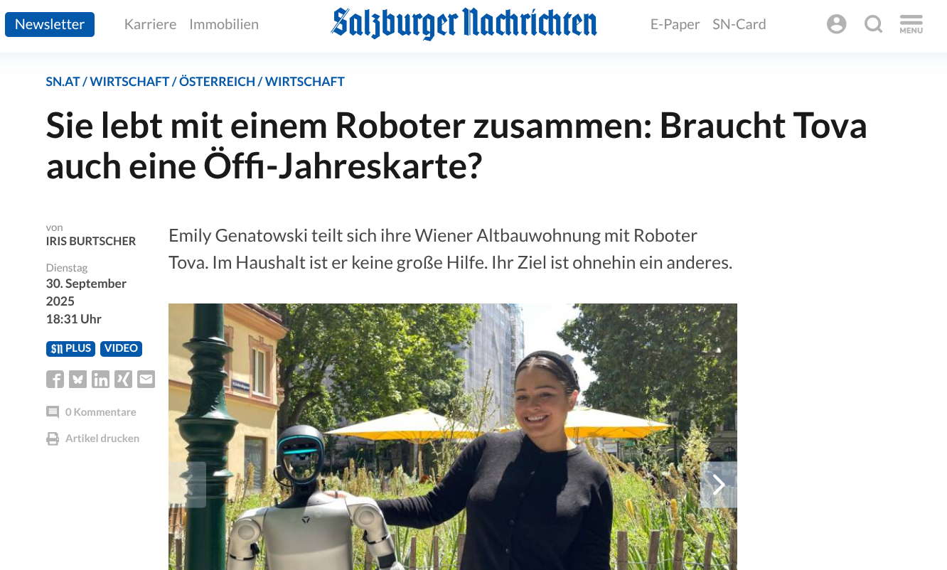 A woman smiling outdoors next to a humanoid robot with a round head and digital face, in a park-like setting with trees and yellow umbrellas.