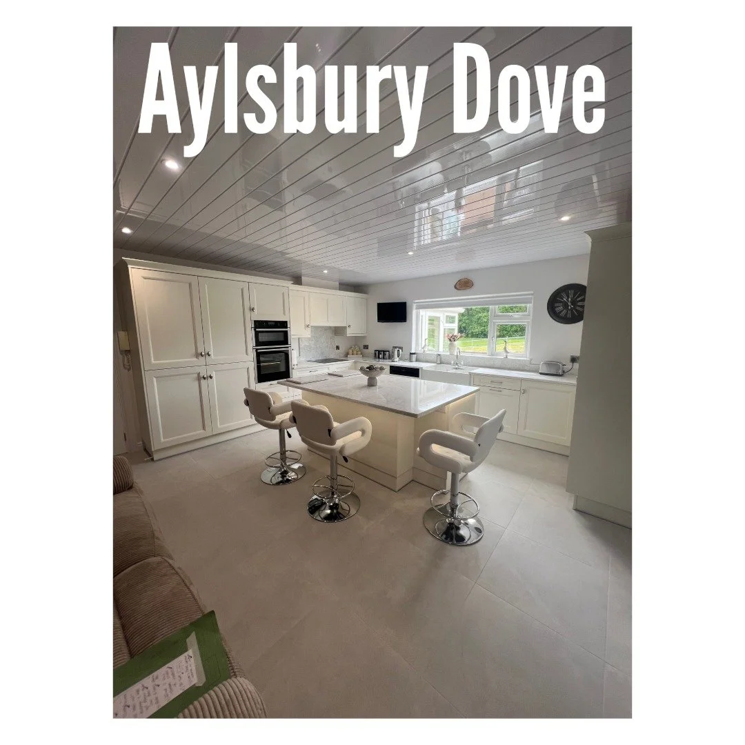 This beautiful Aylesbury Dove Kitchen combines soft neutral tones with striking details, featuring sleek Calypso Quartz worktops and LED strip lighting around the island to give the space a warm modern glow. The bi-fold worktop storage keeps surfaces