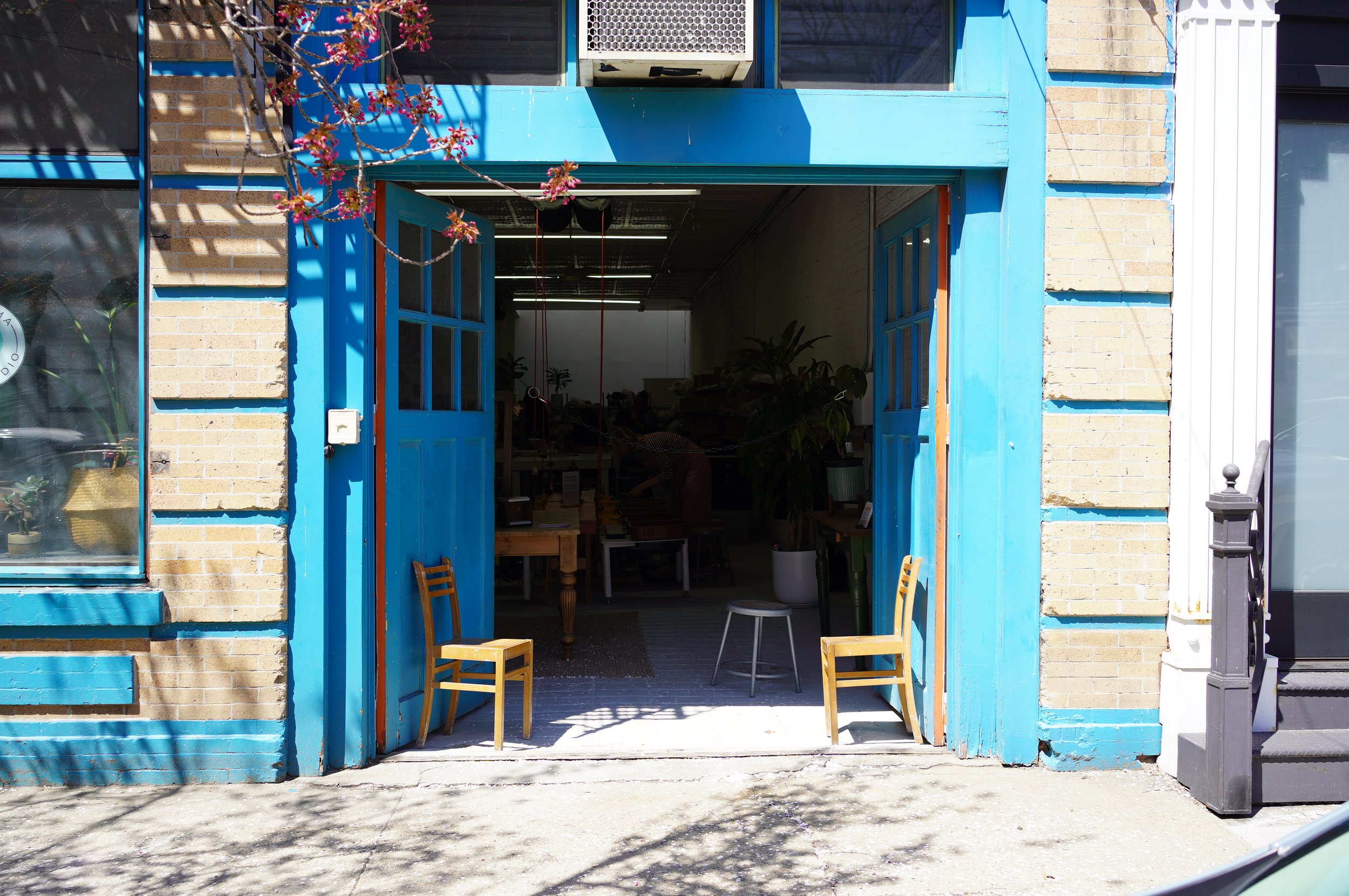 Two large blue doors open invitingly to a ceramics studio.