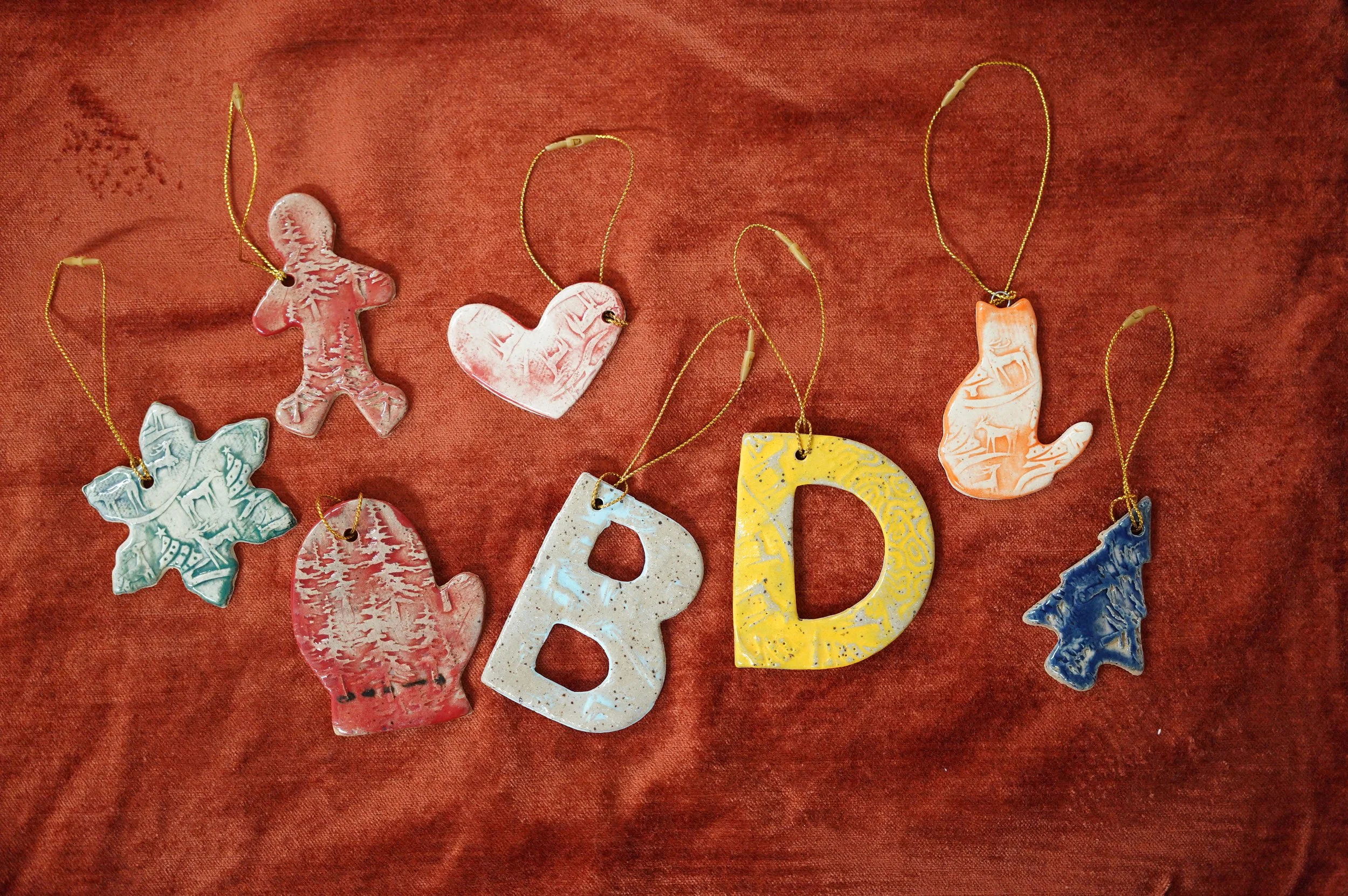 Handmade ornaments in many shapes cover a table.