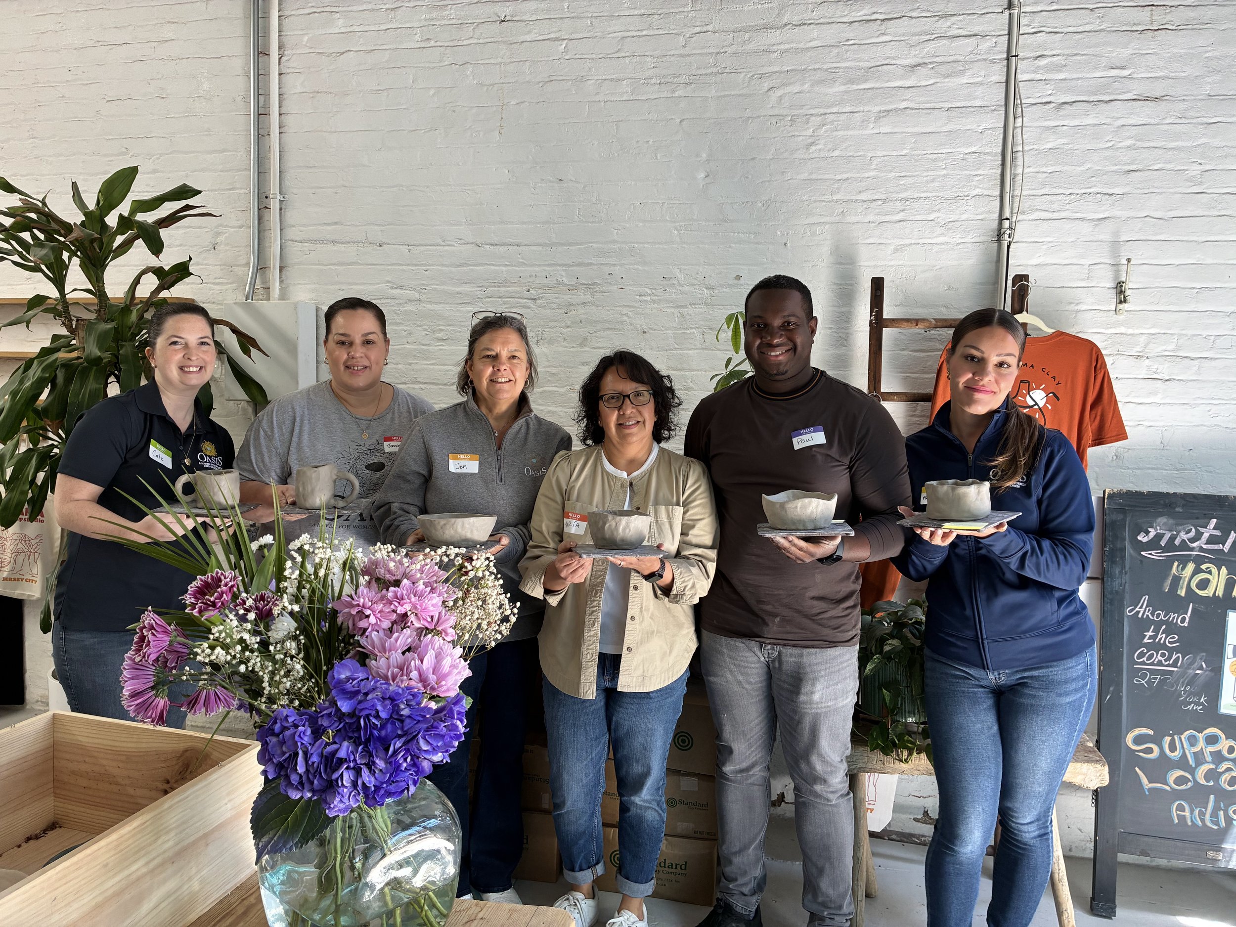 A group of ceramics students proudly display their handmade bowls.