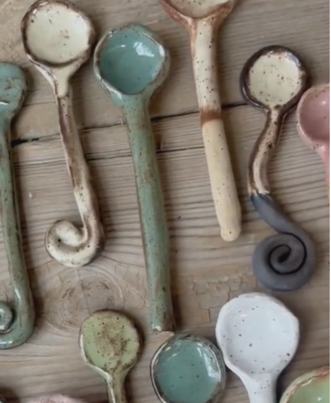 Whimsical handmade spooons crowd a tabletop.