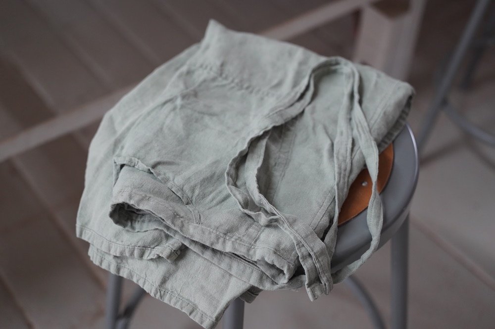 A linen apron lies folded on a stool in a potter's studio.