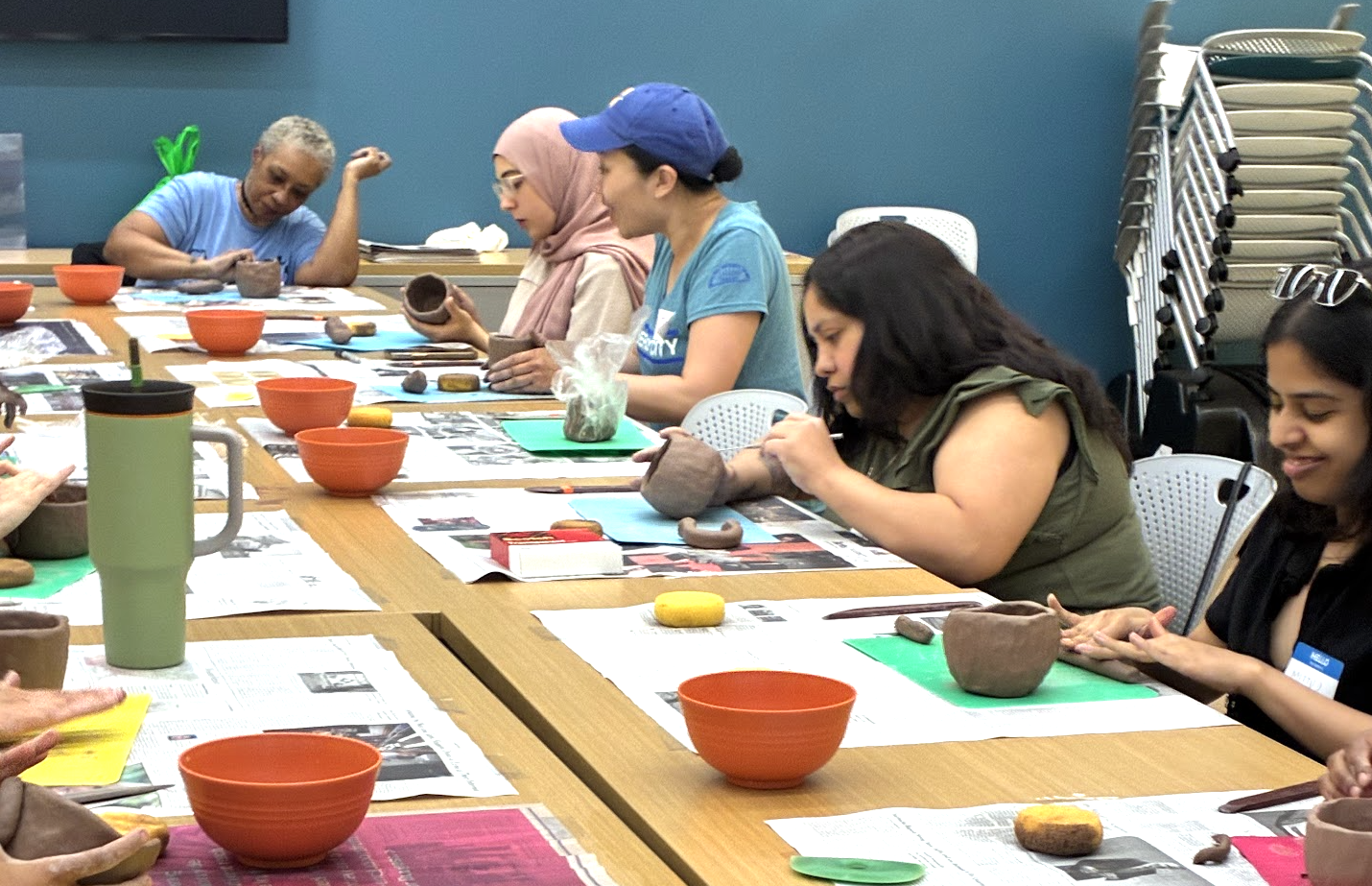 Novice potters make mugs and bowl in a beginner's pottery class.