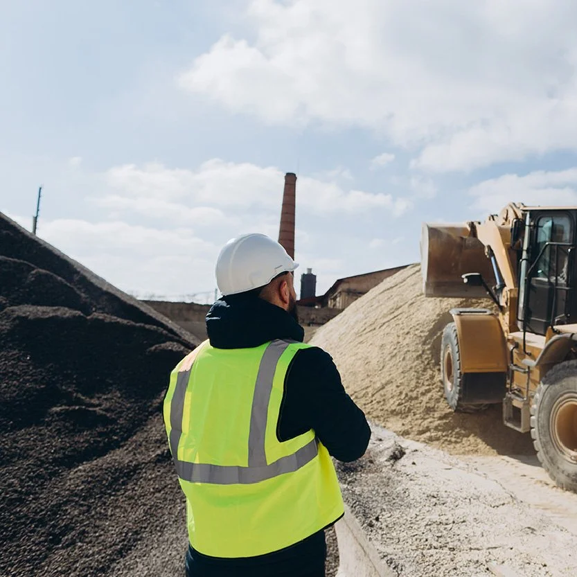 Man looking at tractor piling up aggregate