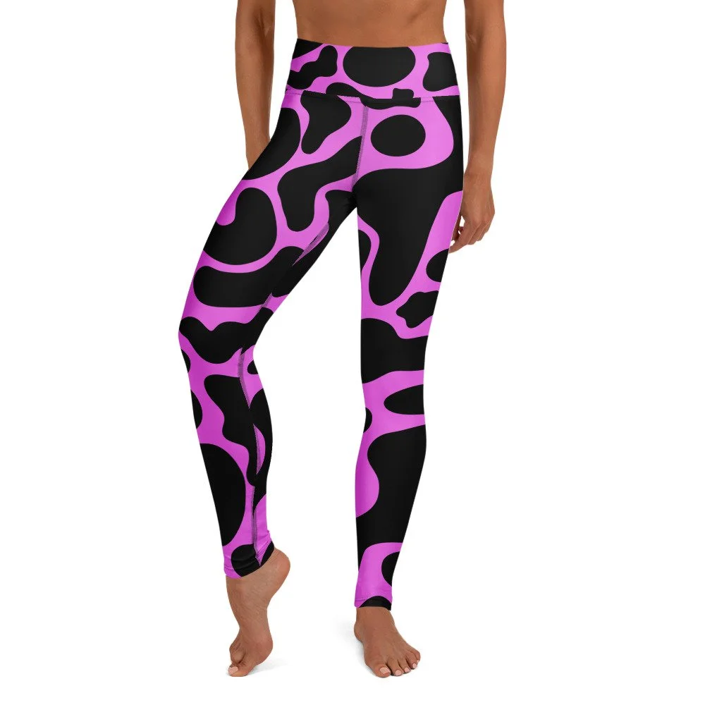 Person wearing black and pink patterned leggings with abstract shapes, standing barefoot.