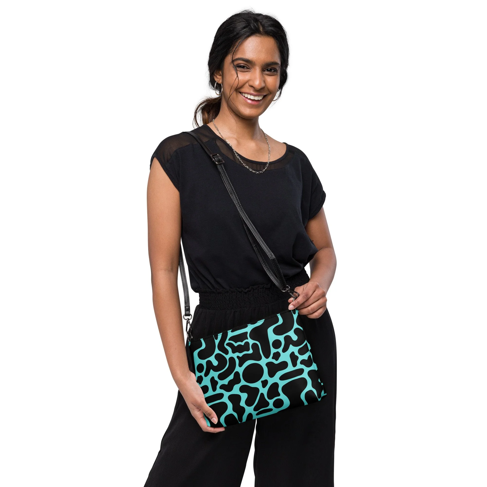 Woman wearing black clothing holding a turquoise and black patterned purse