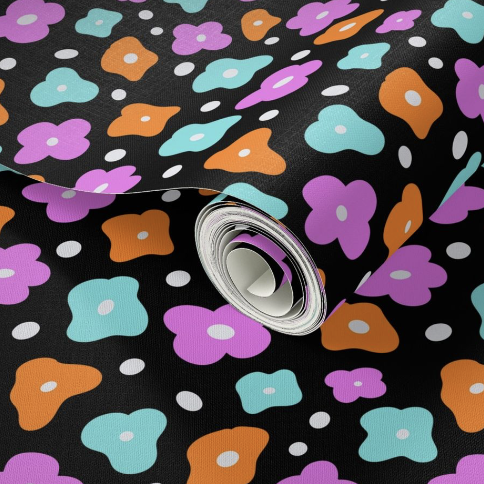 Rolled fabric with colorful floral pattern on black background.