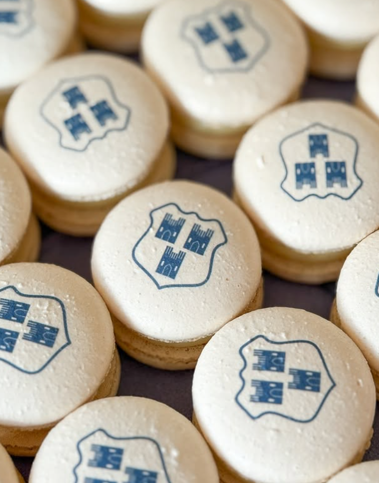 Cookies with a blue emblem or logo printed on top, arranged on a surface.