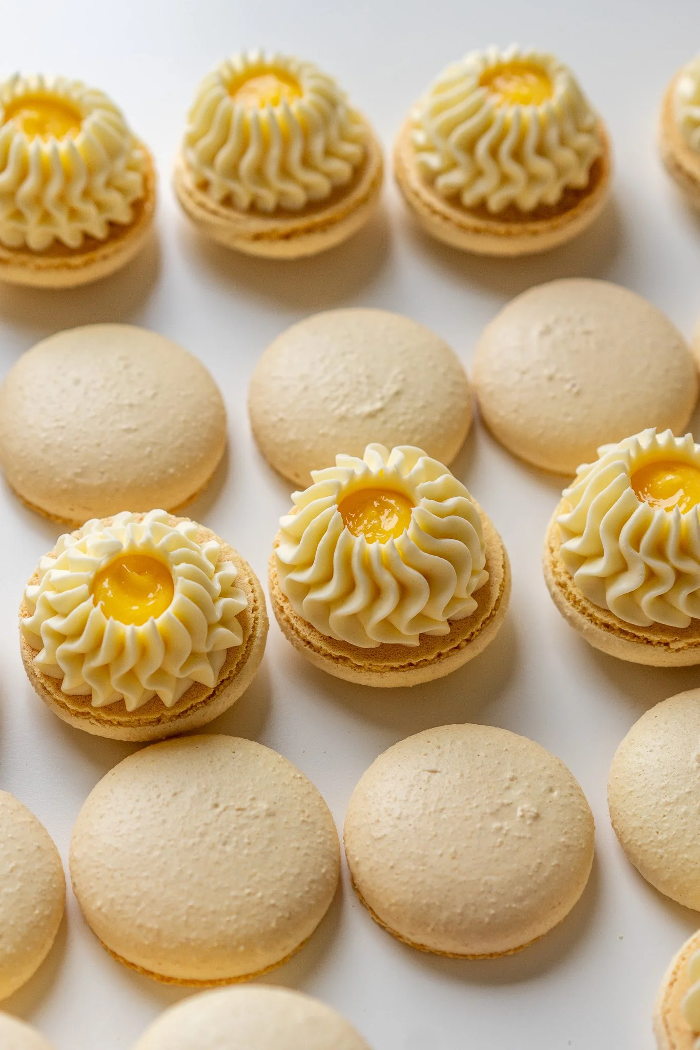 lemon macarons with a lemon curd in the middle of them and ganache on the outside