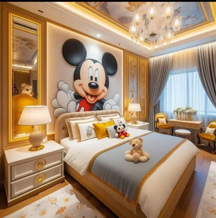 A bedroom with Mickey Mouse themed decor featuring a large Mickey Mouse portrait on the wall, plush toys on the bed, and yellow and gray accents.