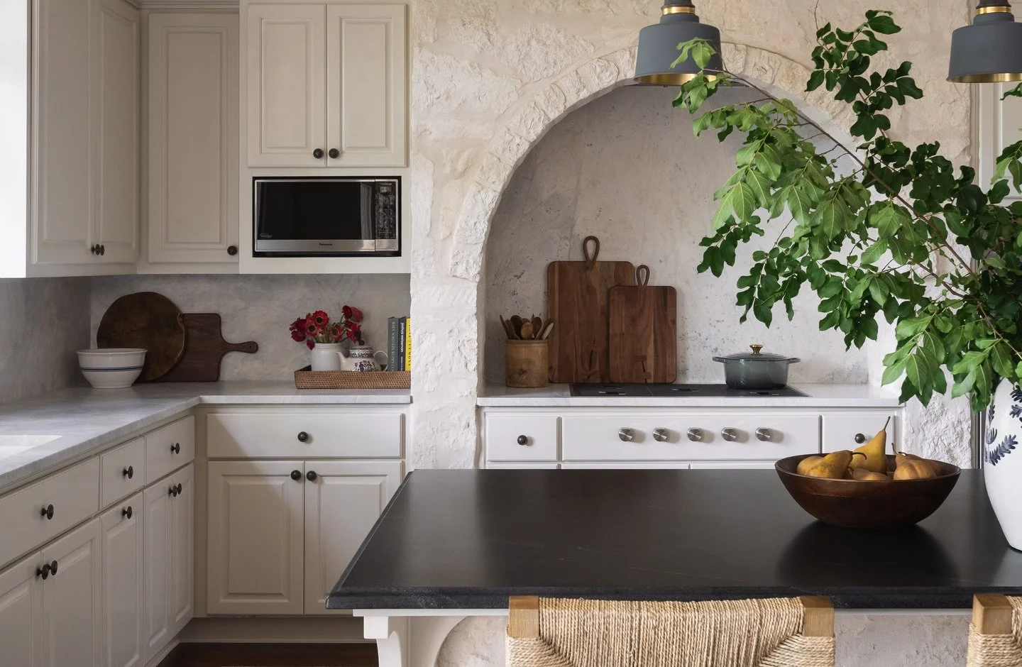 Two types of stone&hellip;or three if you count the limestone!  One very good decision.

Perimeter and backsplash: Matterhorn marble
Island: leathered Black Mist granite

The contrast is subtle, timeless, and proof that mixing stone is where the magi
