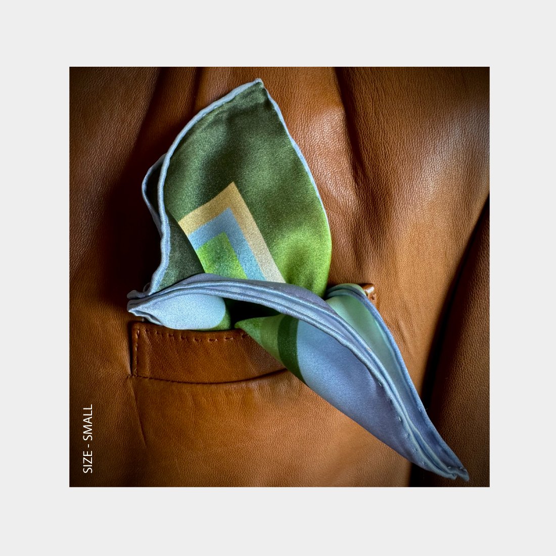 "Diversion" is shown as a Pocket Square bursting with green and lilac tones from the breast pocket of a brown leather jacket.