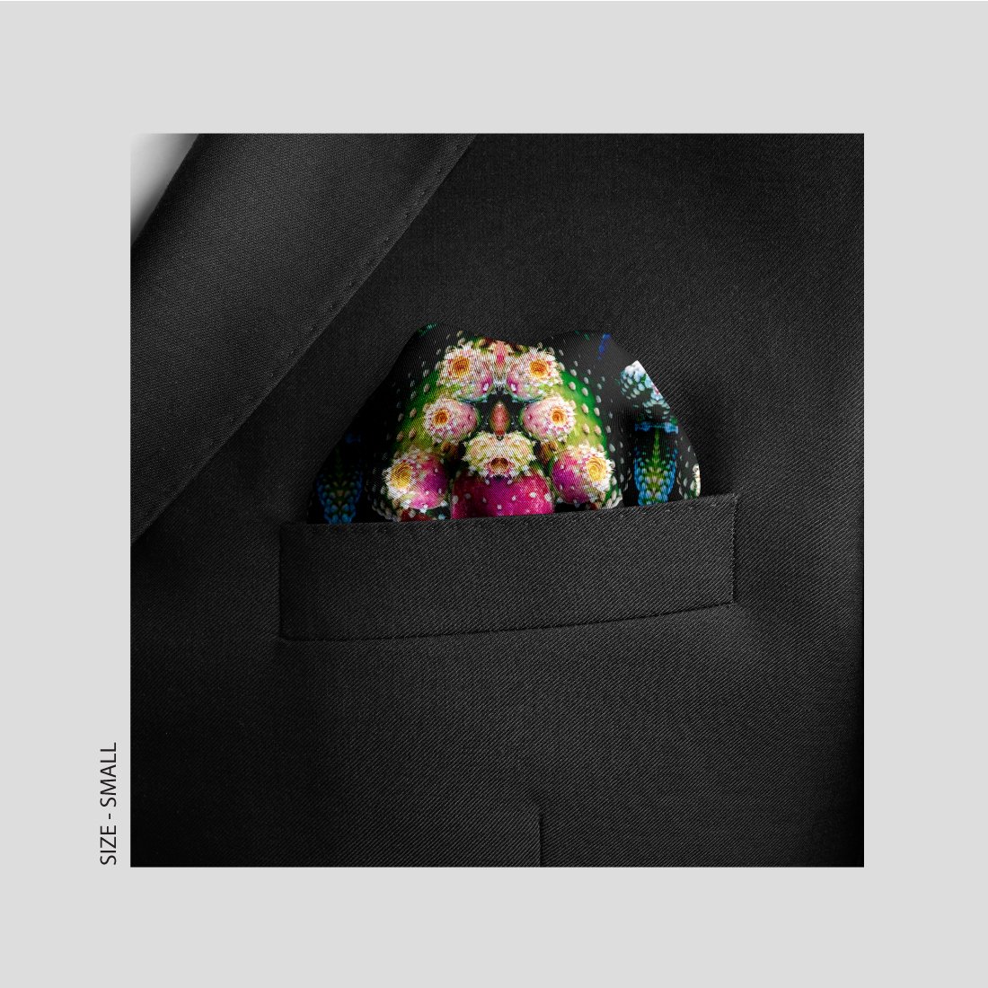 Exotic Fruit 100% silk scarf is shown here pocket sized in a dark lapel pocket.