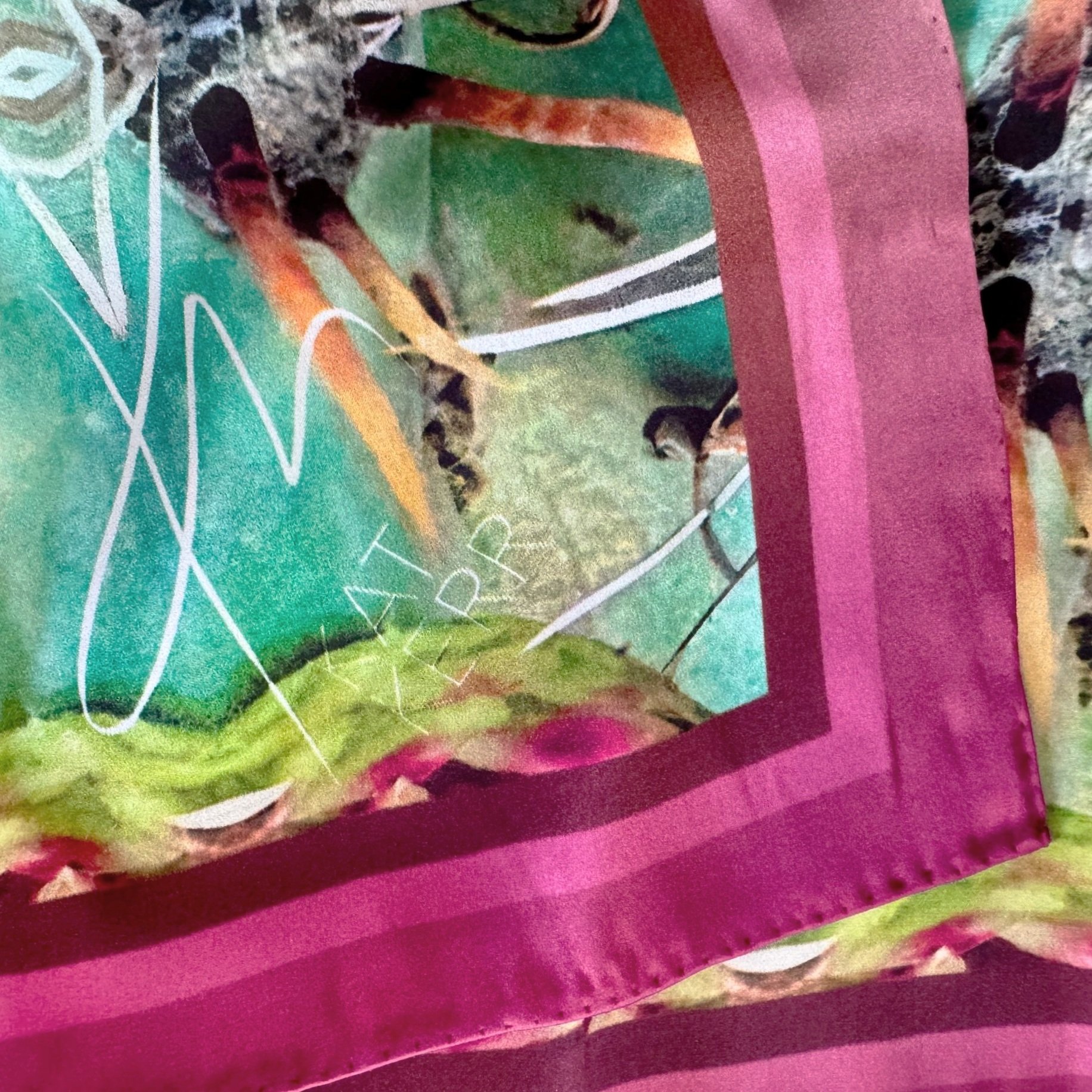 Corner Detail of "Arizona" silk scarf showing hand sewn edges, textures, dolbe sided printing, logo and label