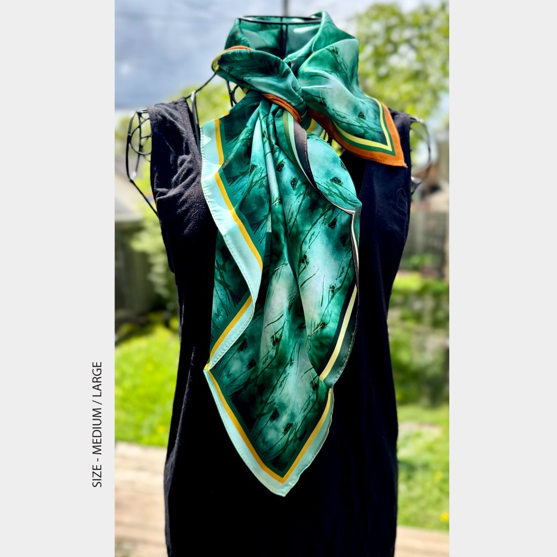 Mannequin wearing "Quenched" silk scarf, size either medium or large, hanging in down the front of a black sleeveless dress