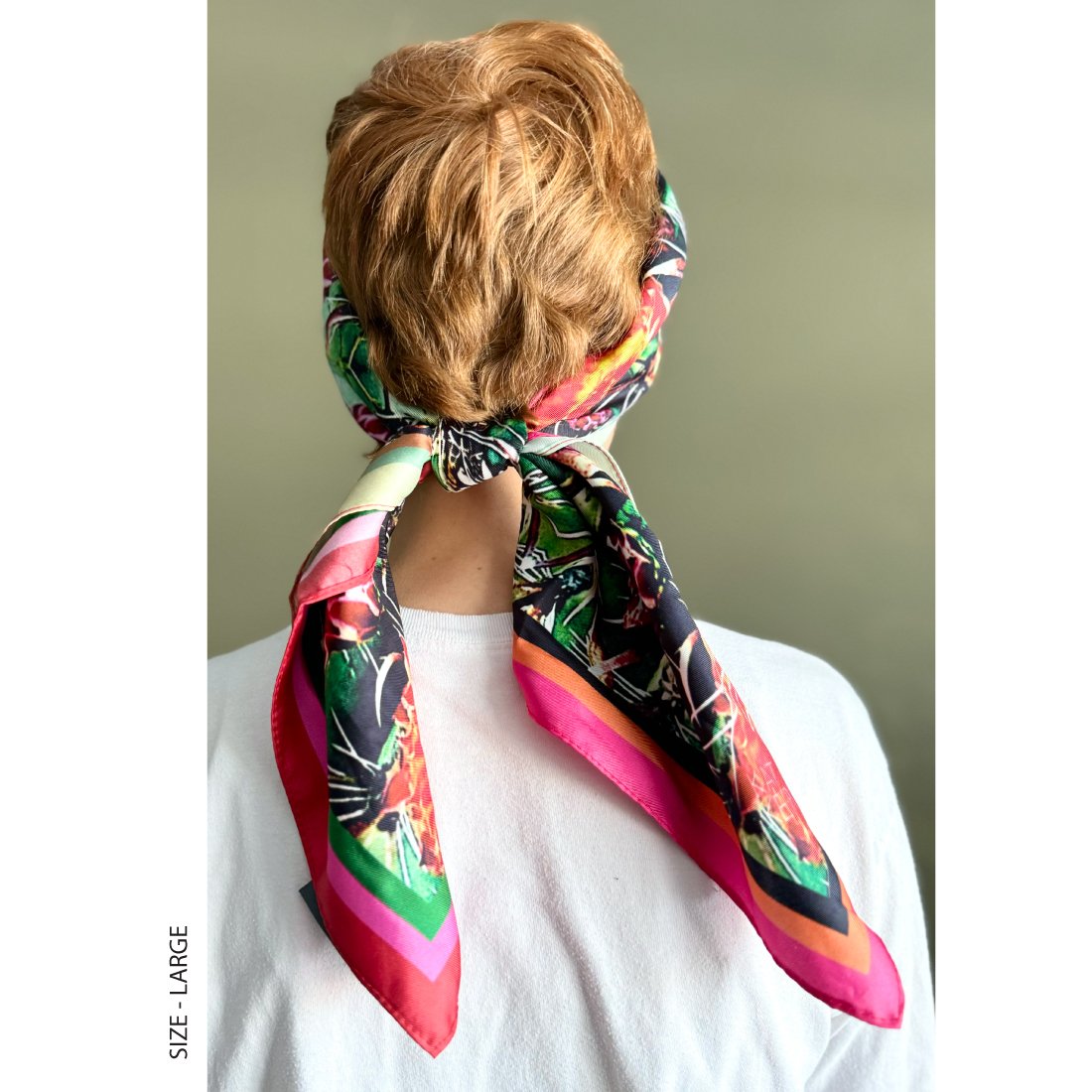 A woman with short red hair wears "Phoenix" silk scarf size large in her hair, tied at the back.