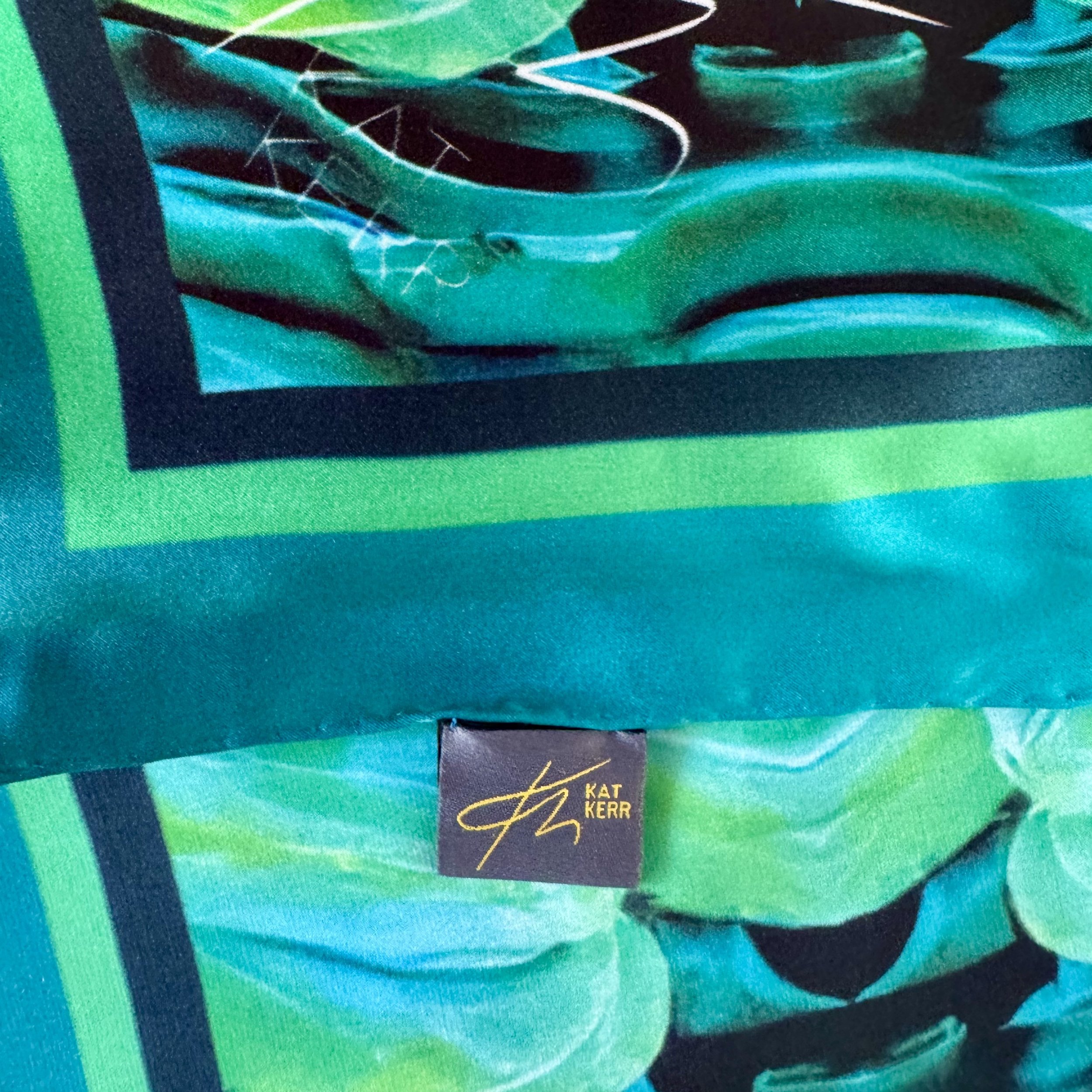 Corner edge detail of "the Life of Water" showing logo and label as well as quality of double sided printing, hand sewing and satin texture