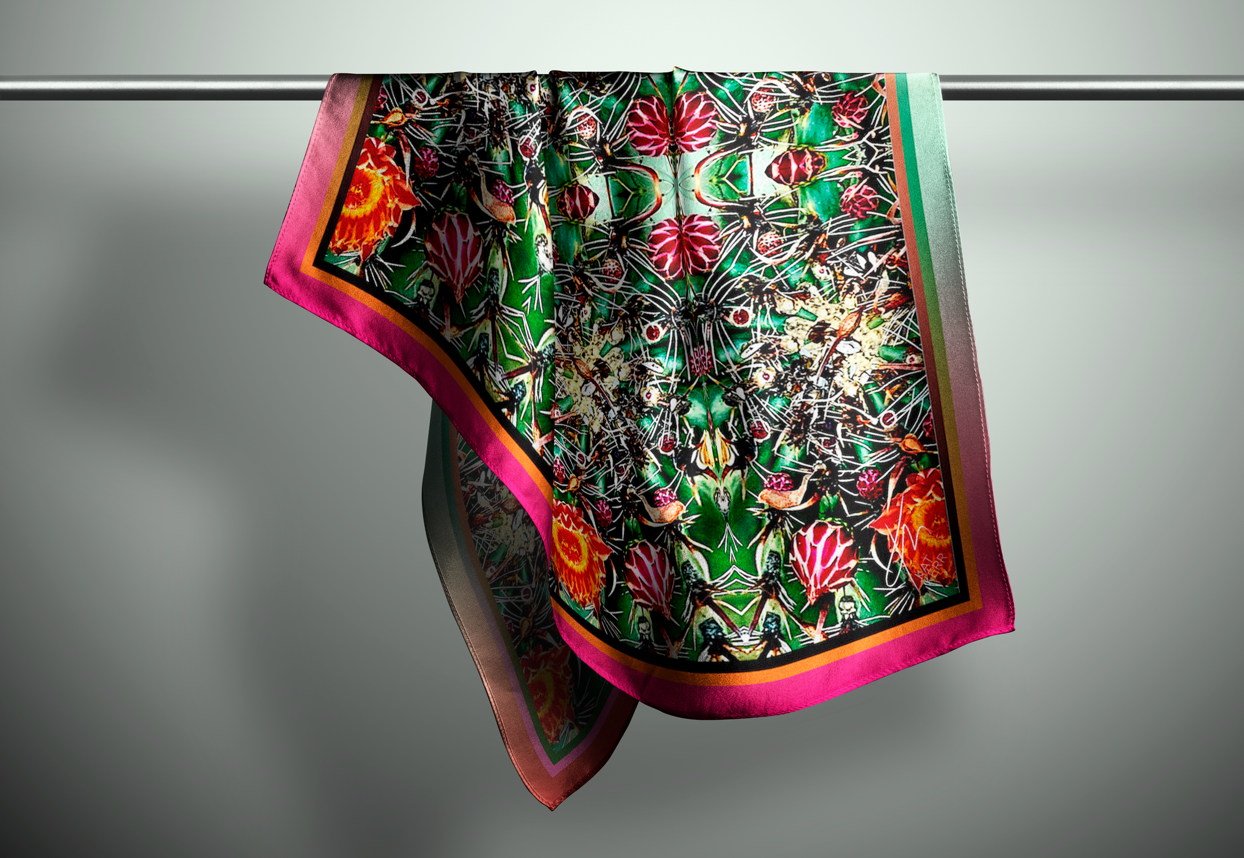 a multicoloured silk scarf hanges form a rod in a plain space.