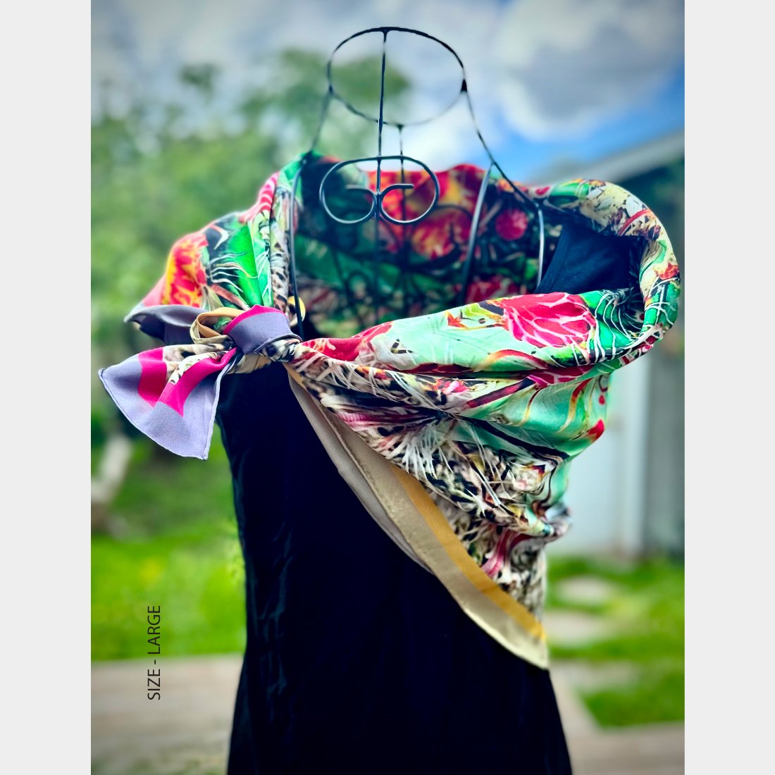 Mannequin wearing "Desert Blooms" silk scarf, size either medium tied asymmetrically at one shoulder of a sleeveless black top