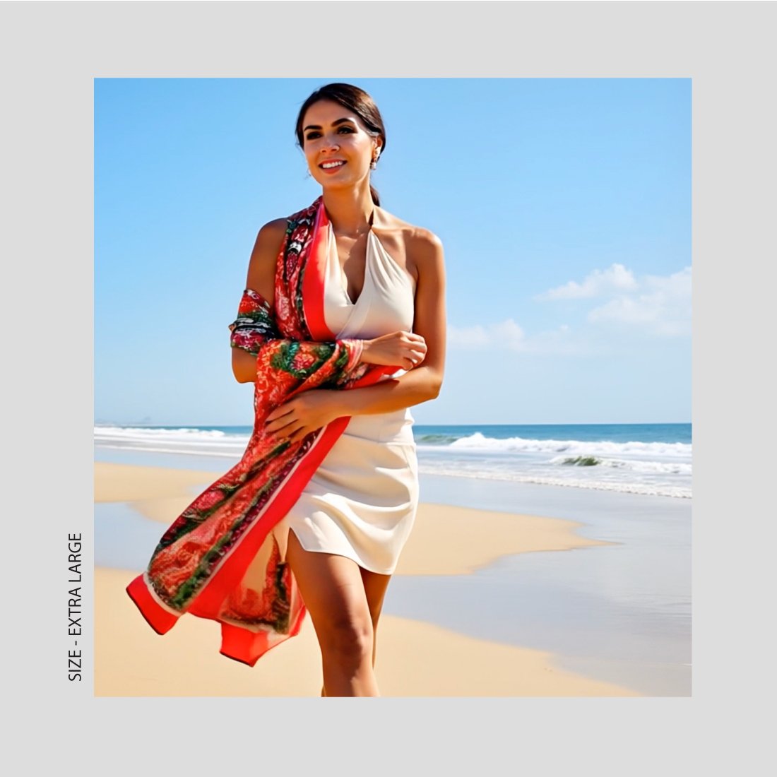 A woman in a white dress wears a vibrant red patterns extra large sized scarf at the beach