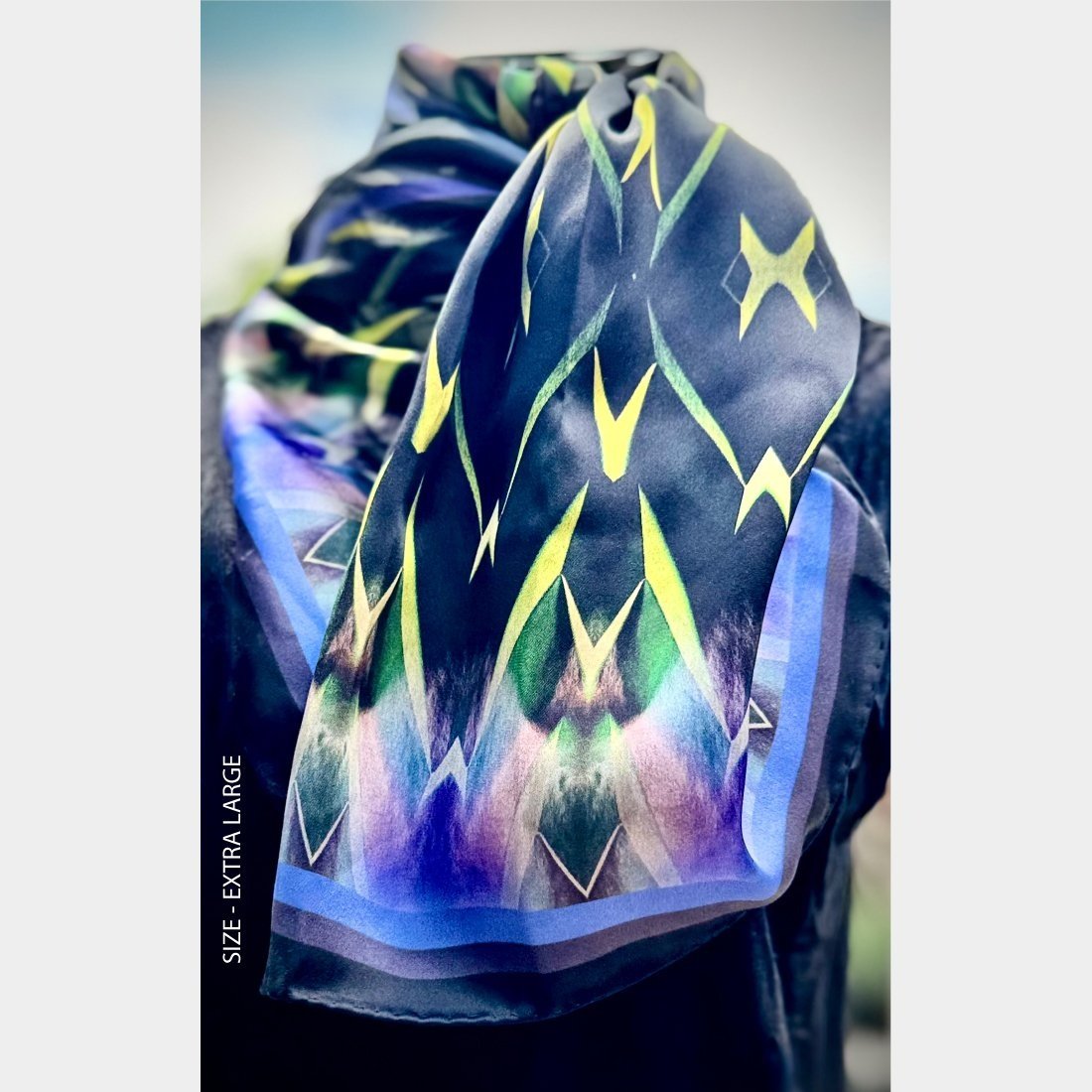 "Centuries of Healing" silk scarf size extra large is wrapped around the neck of wire mannequin an folded over the bodice.