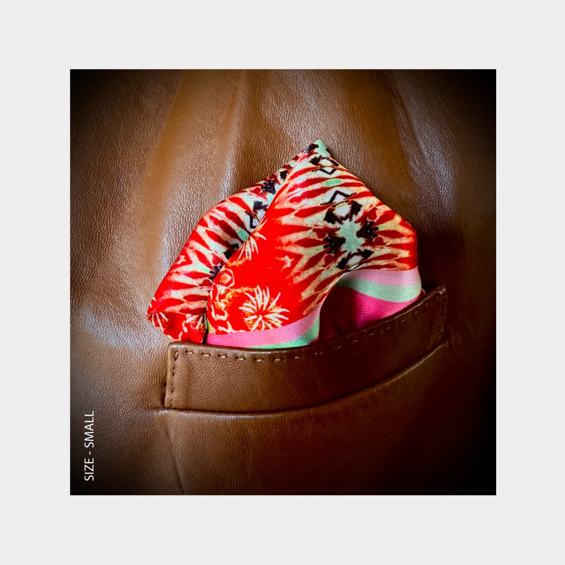 "This Flowering Desert" is shown is a Pocket Square folded for a pop of red pattern in the breast pocket of a copper leather jacket.