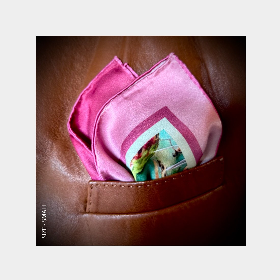 "Arizona"" is shown as a Pocket Square offering a burst of pink, mauve, and teal, from the breast pocket of a copper leather jacket.