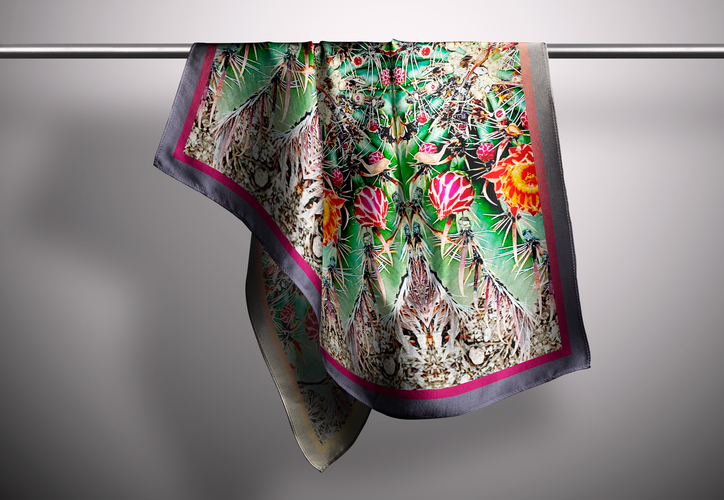 A boldly flowered scarf hangs from a rod in a neutrally lit space.
