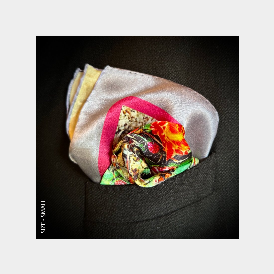 "Desert Blooms" is shown as a Pocket Square offering a burst of floral tones from the breast pocket of a black wool jacket.
