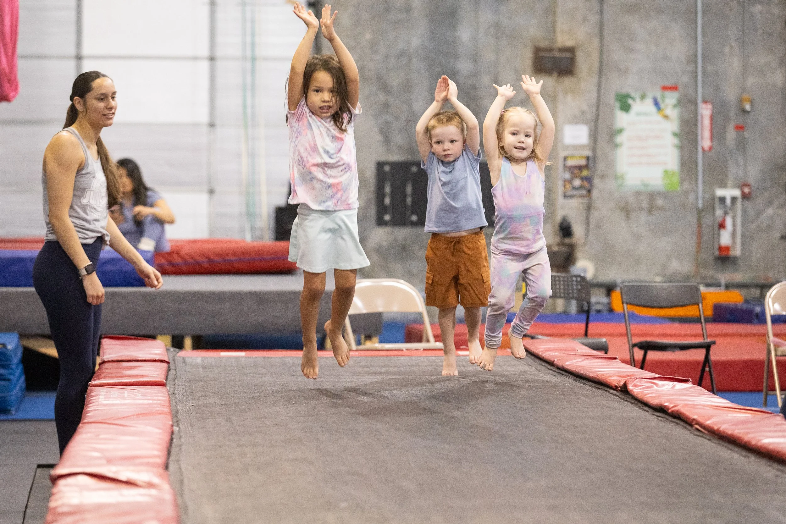 Group of children stretching in a gym with an instructor.