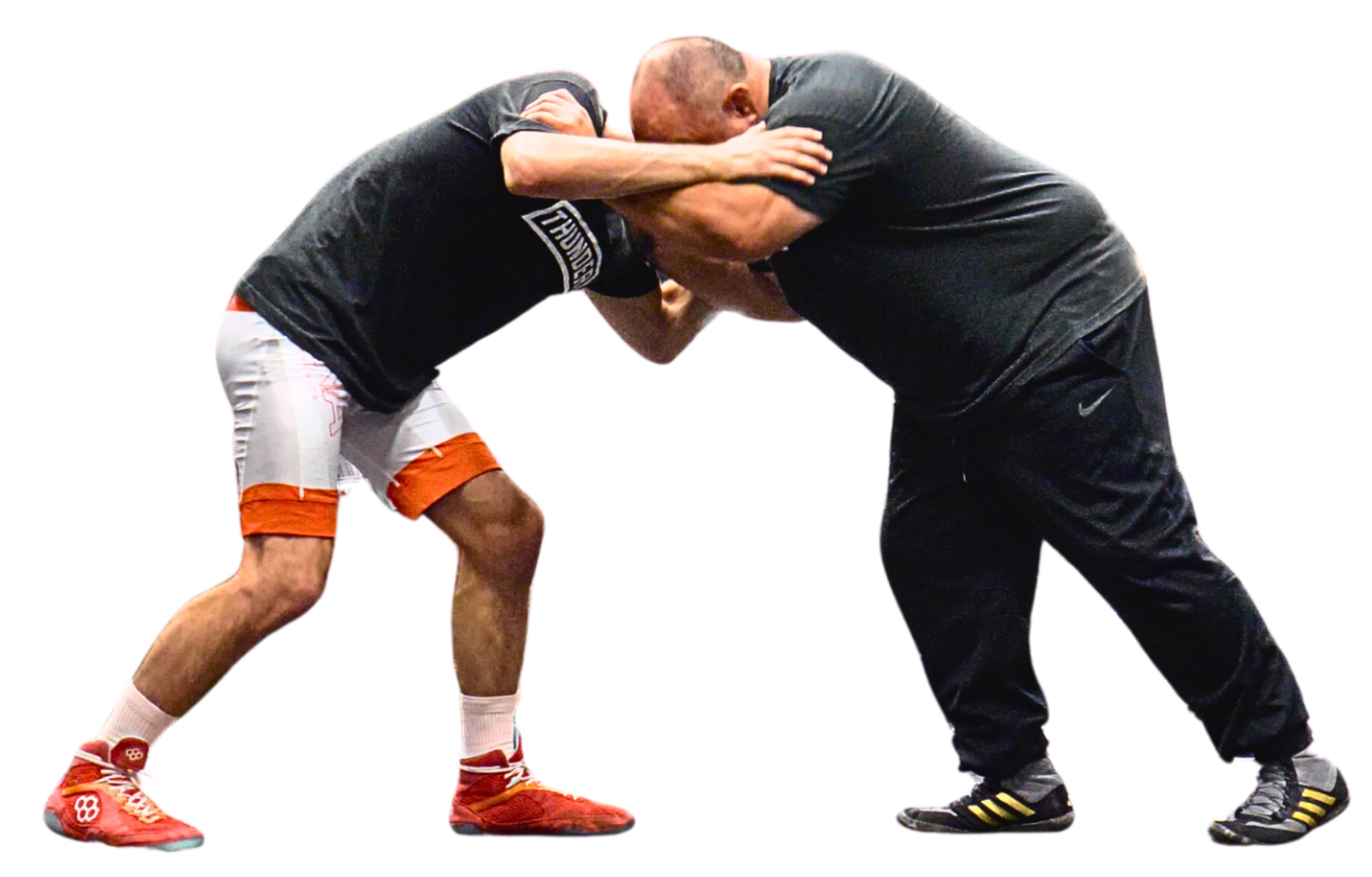 Two men engaged in a wrestling match, both leaning forward with arms locked and heads pressed together.