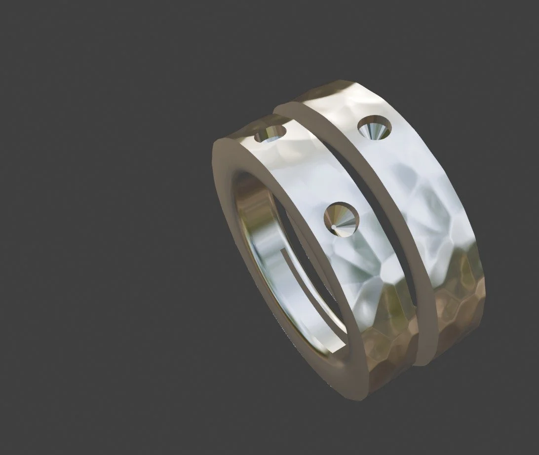 Two metallic rings with hammered texture, positioned at an angle against a dark background.