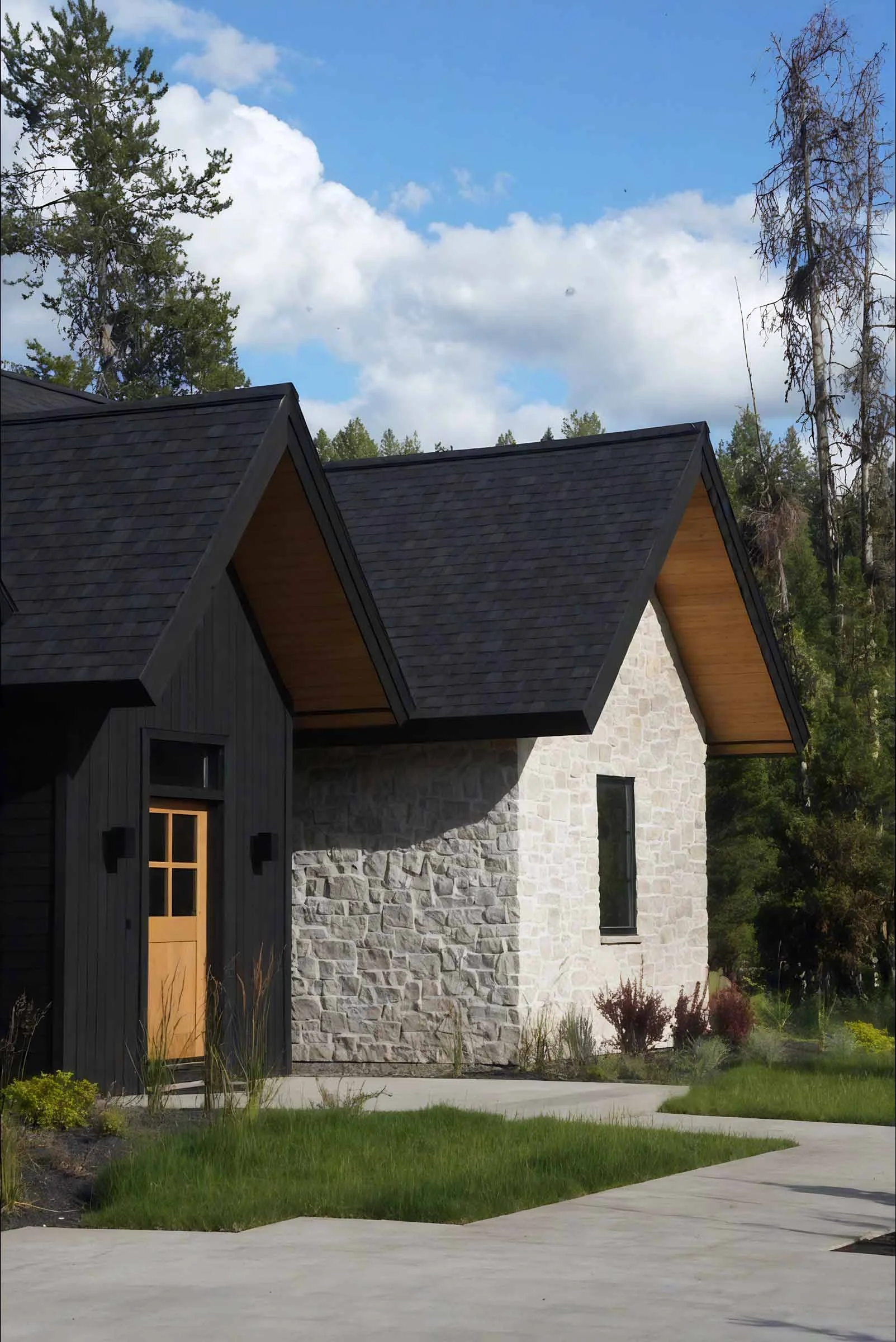 Refined entry detail of a custom home by Jakub Galczynski, featuring stone and wood elements supported by high-end residential structural engineering.