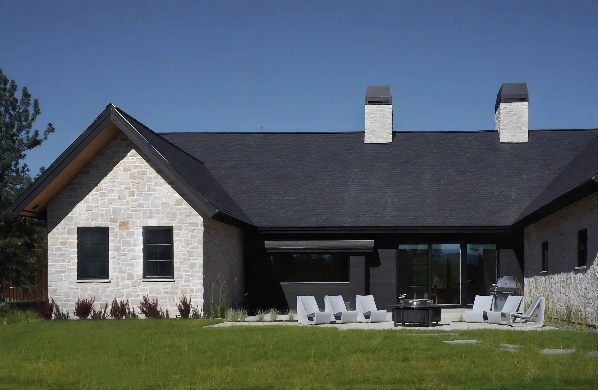 Rear exterior of a custom riverfront home designed by Galczynski Studio, showcasing outdoor living supported by durable structural engineering by Boise residential engineer Plan North. 