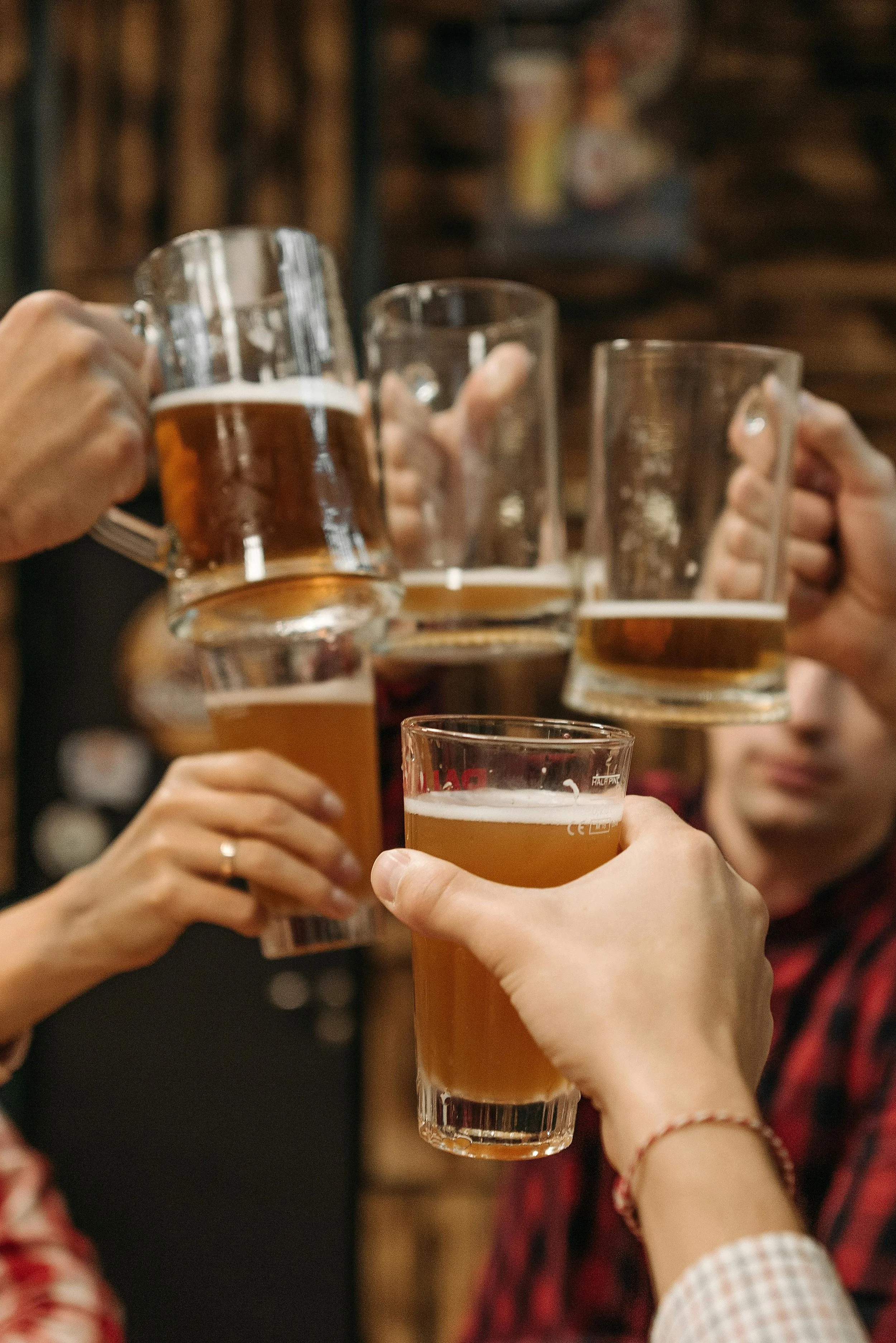 Four people doing a cheer with beer