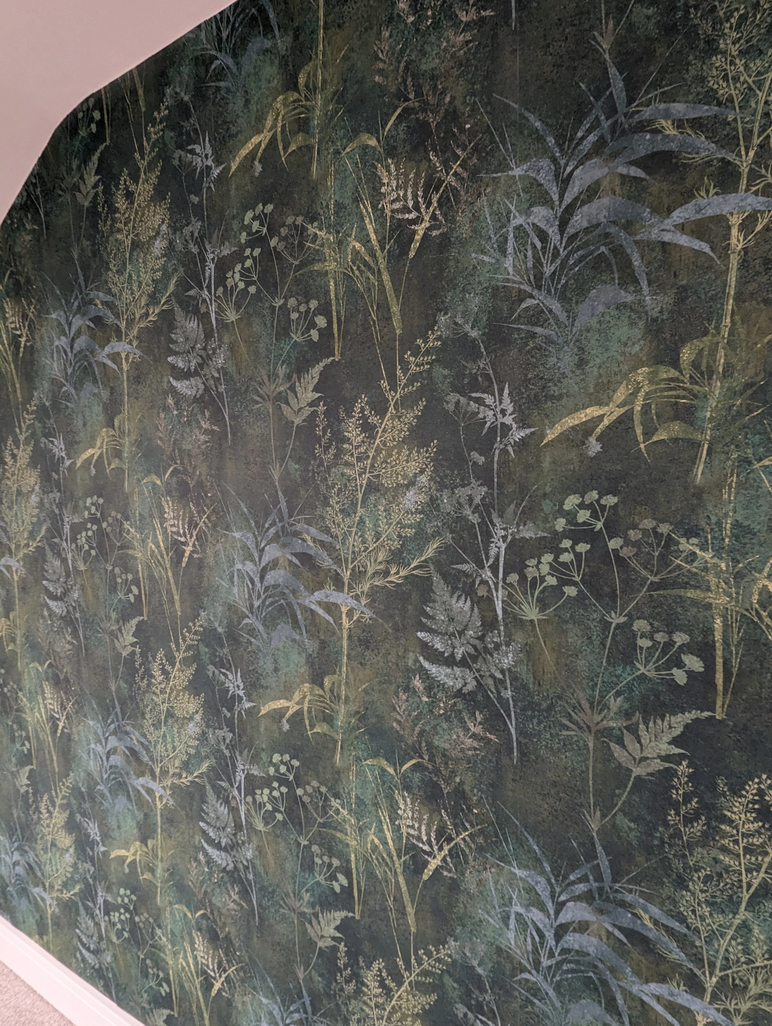 Wallpaper featuring a dark, greenish background with various illustrations of grass, plants, and ferns in lighter shades.