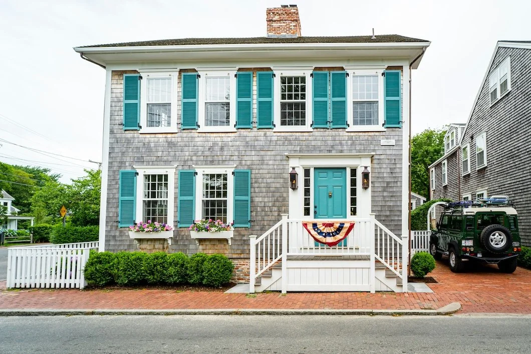 grey and white shingled nantucket home with aqua-green shutters