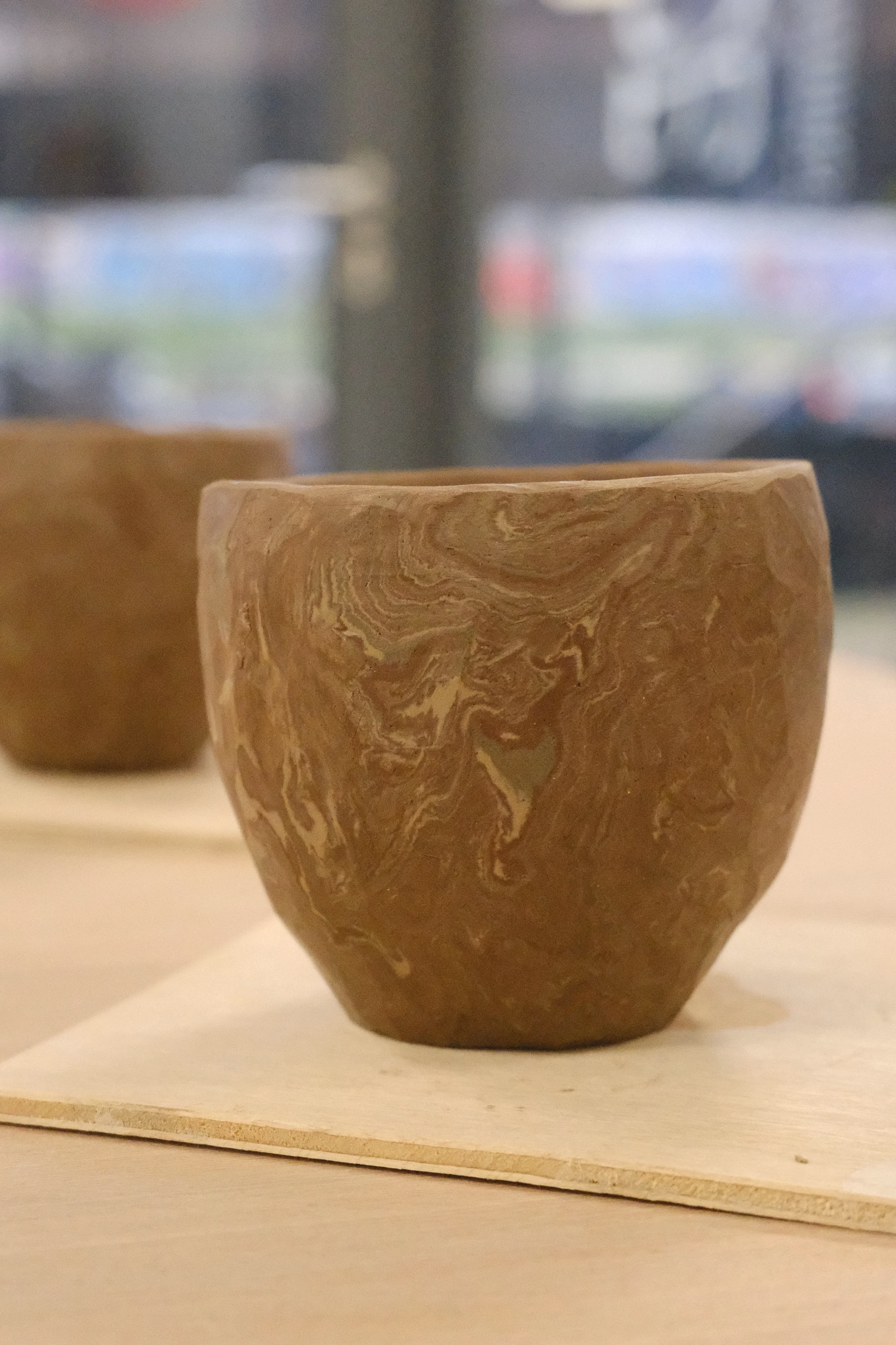 nerikomi patterned clay being shaped into a handmade cup