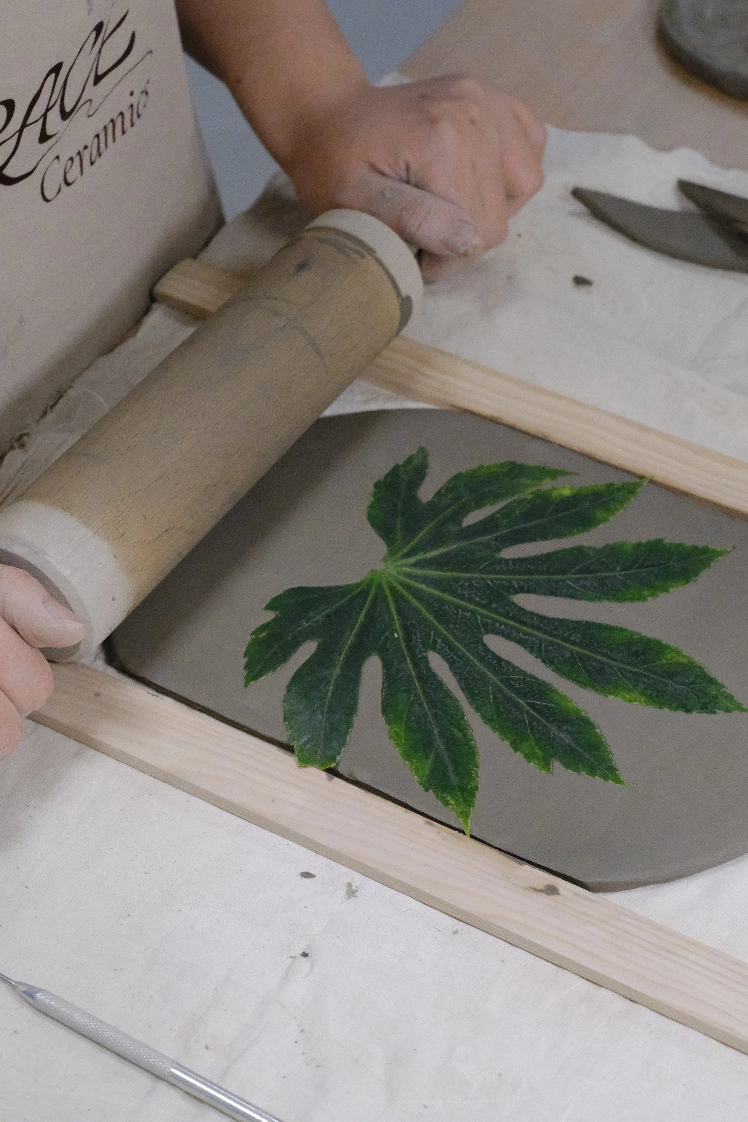 clay printing with leaves on a slab built ceramic plate