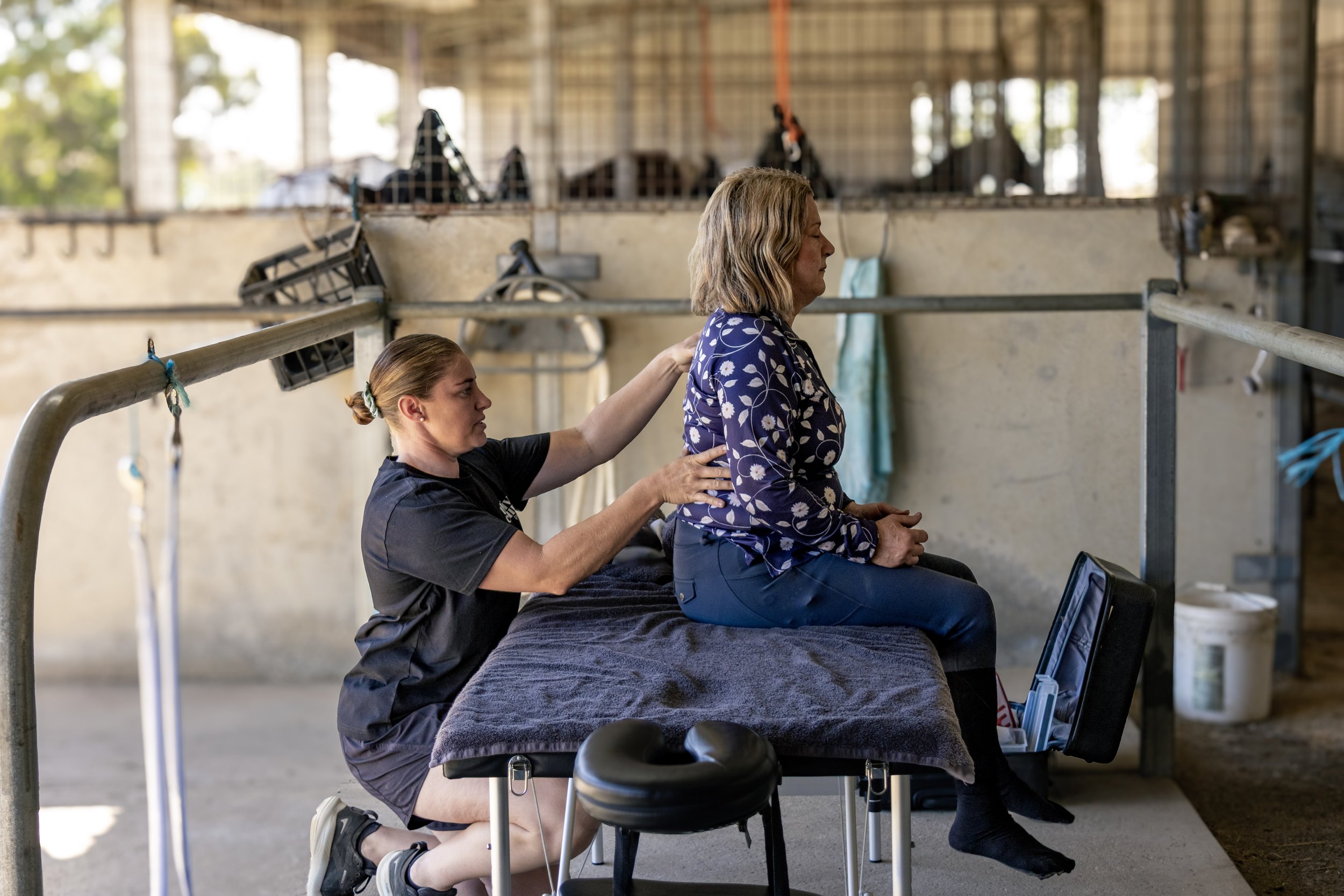 A rider receiving physiotherapy treatment to improve their spinal mobility so they have less pain and can sit trot more effectively.