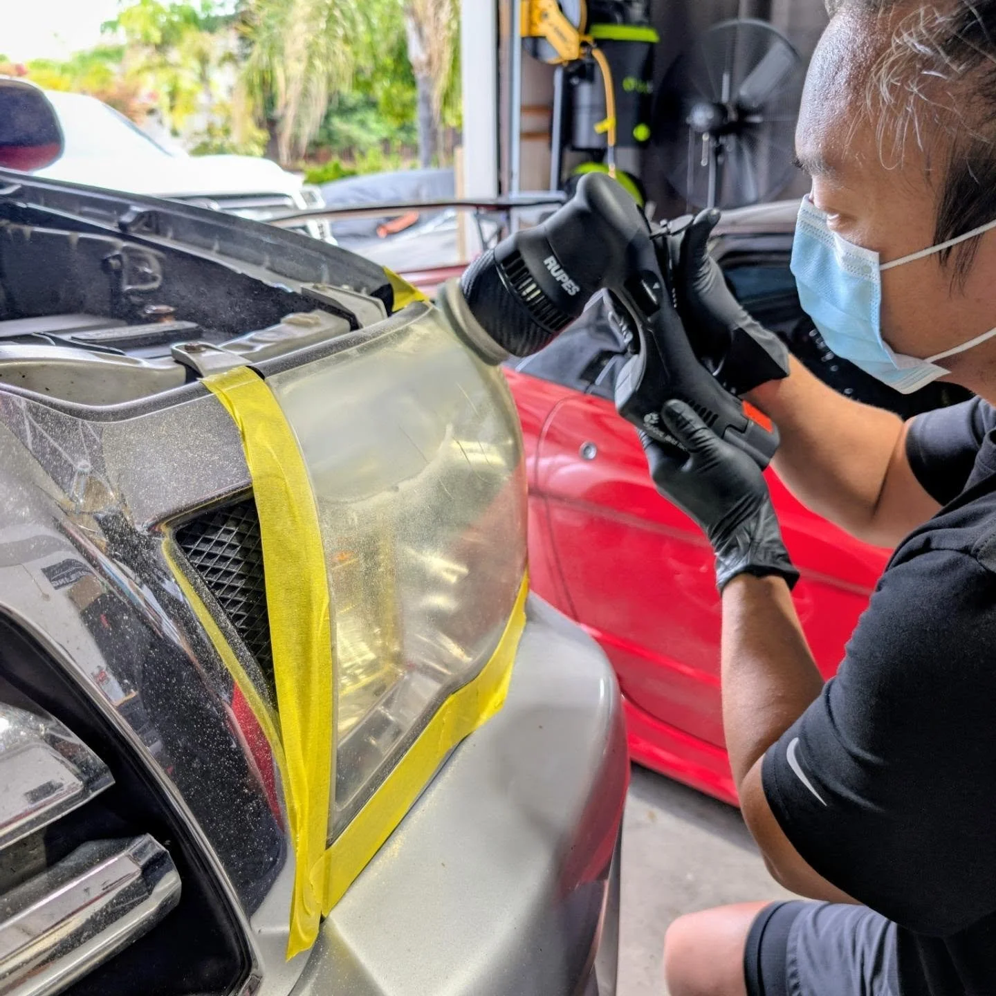 Detailer performing headlight restoration 2005 Toyota Tacoma SR5
