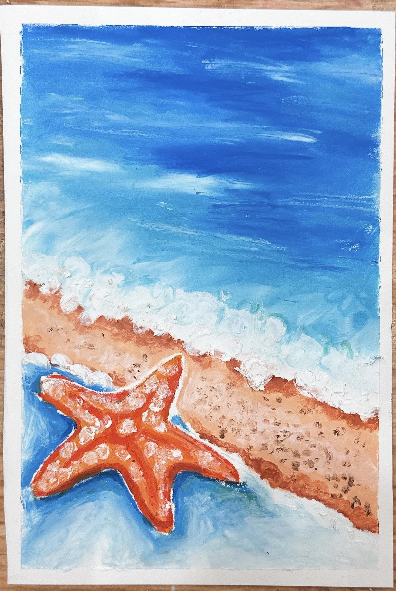 A painting of a starfish on a beach, with a blue sky and ocean in the background.