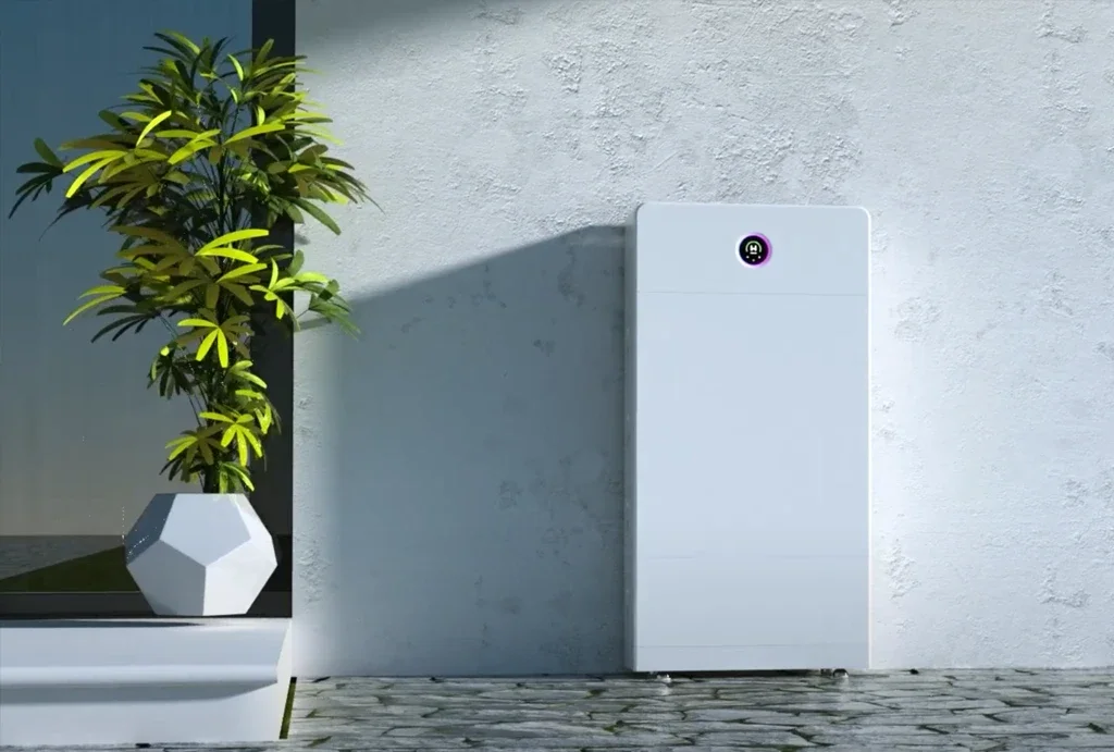 A modern outdoor scene featuring a potted plant with green leaves on a white surface and a white, rectangular smart device or appliance against a light gray textured wall.