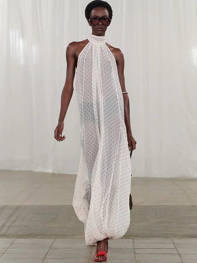 Runway Recap: @rotatebirgerchristensen Spring / Summer 2026 turns up the heat with a &rsquo;70s twist. 

Fluid capes, sheer gowns, scarf-tied dresses, and sun-kissed tailoring. The collection blends warm, golden-hour nostalgia with modern refinement,
