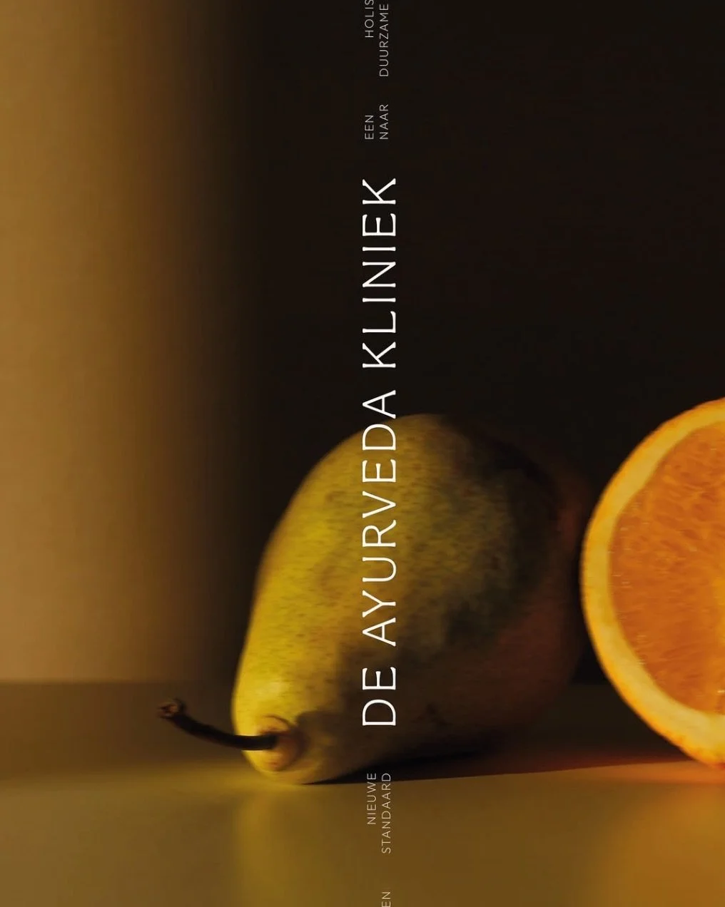A whole pear and a half an orange on a dark background with text overlay.