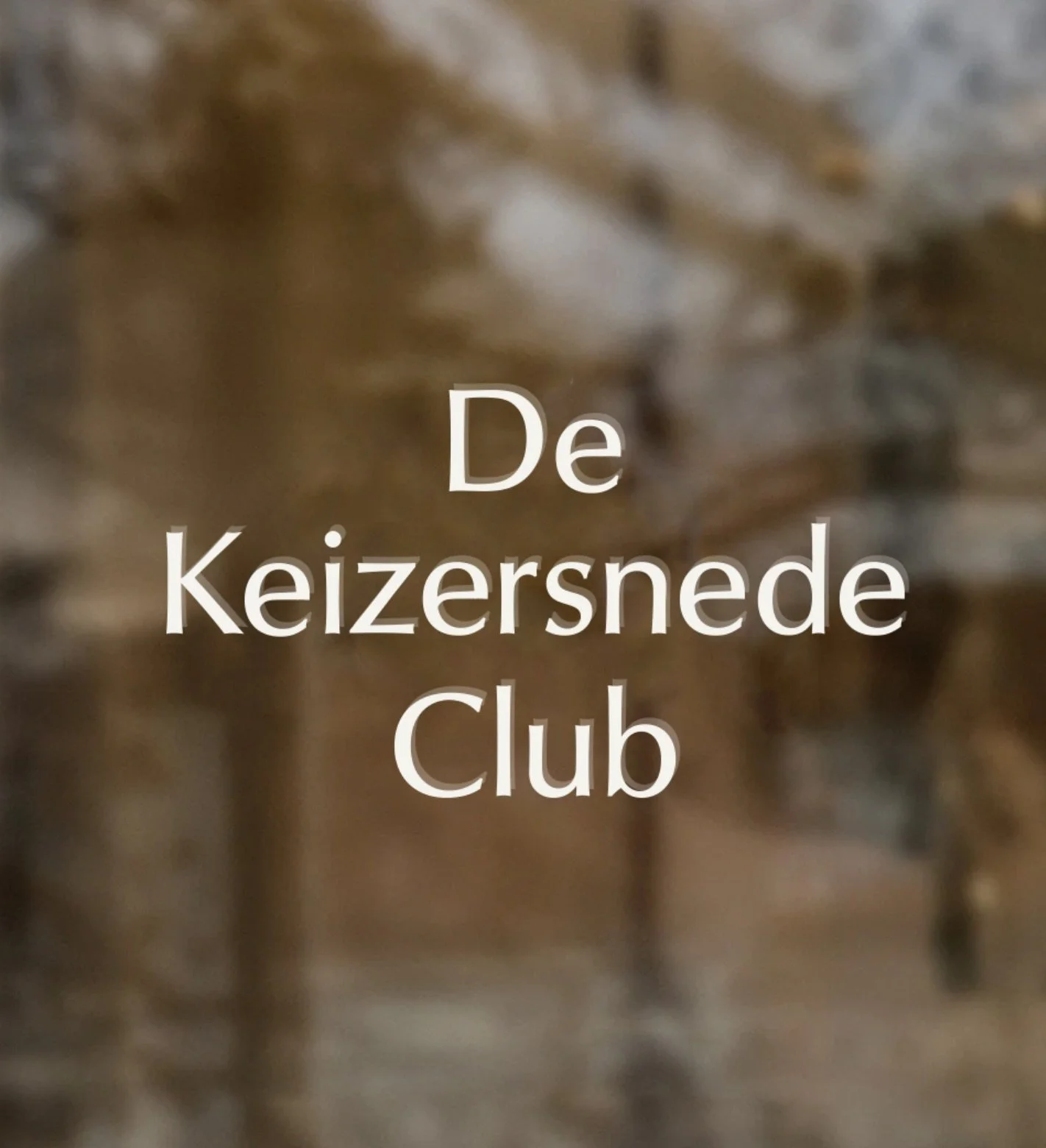 Text over a blurry brown backgroundreading 'De Keizersnede Club'