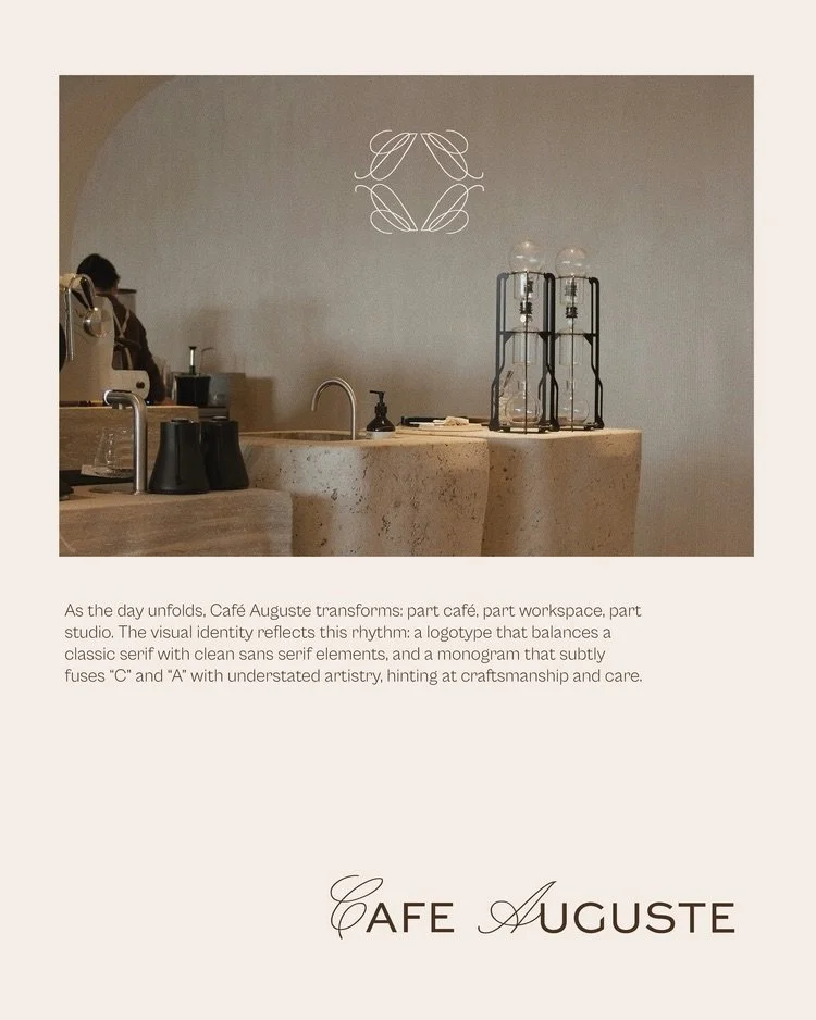 A minimalist cafe interior with a light-colored stone counter, coffee brewing equipment, and a white wall featuring a simple line art logo of intertwined leaves.