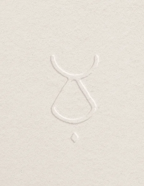 White textured background with a simple embossed outline of a face, featuring a half-circle for hair, a vertical line for the nose, an upside-down U for a mouth, and a small diamond shape below.